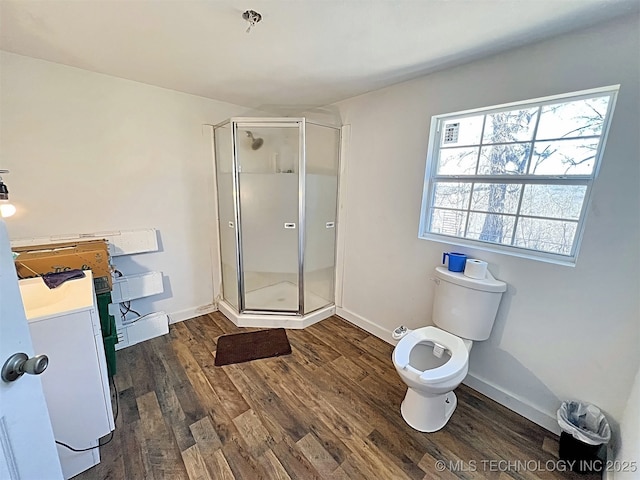 bathroom with vanity, toilet, a shower with shower door, and hardwood / wood-style floors