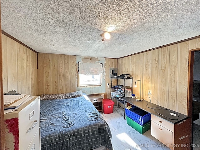 bedroom with a textured ceiling and wood walls