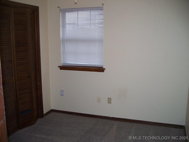 unfurnished bedroom with dark colored carpet