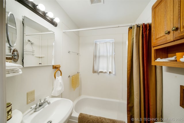 bathroom with shower / tub combo with curtain and sink