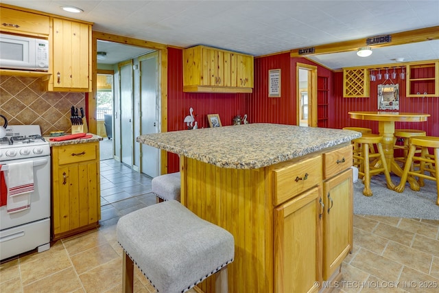 kitchen featuring white appliances, a kitchen island, and backsplash