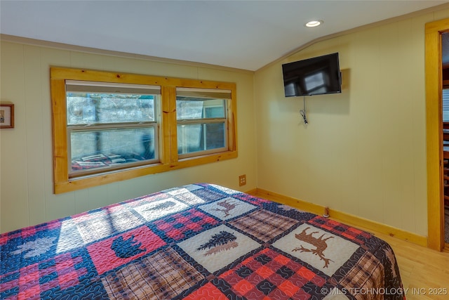 bedroom with hardwood / wood-style flooring and lofted ceiling