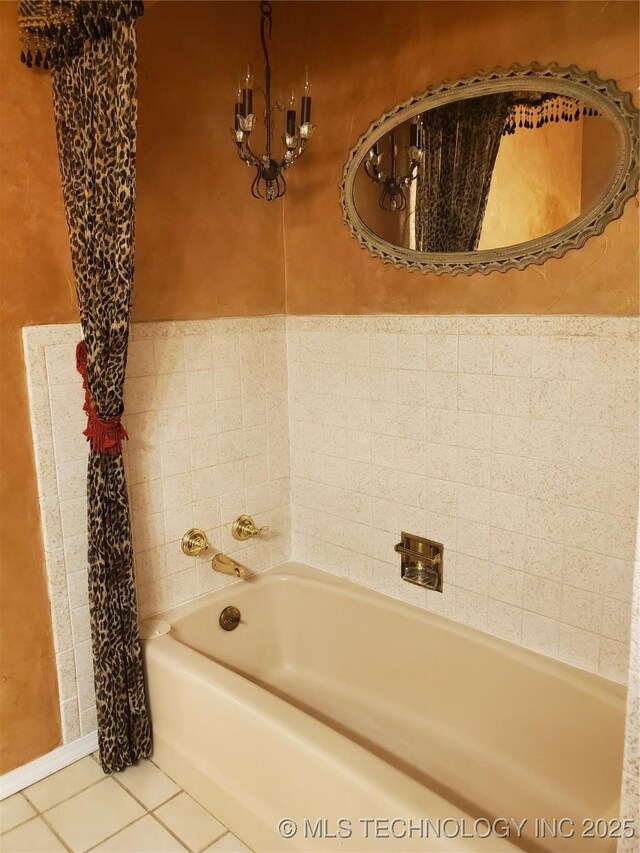 bathroom with a washtub and tile patterned floors