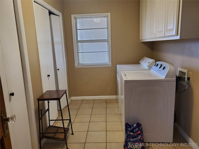 washroom featuring cabinets, light tile patterned flooring, and washer and dryer