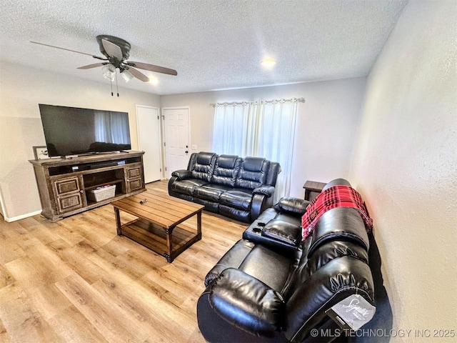 living room featuring wood-type flooring, ceiling fan, and a textured ceiling