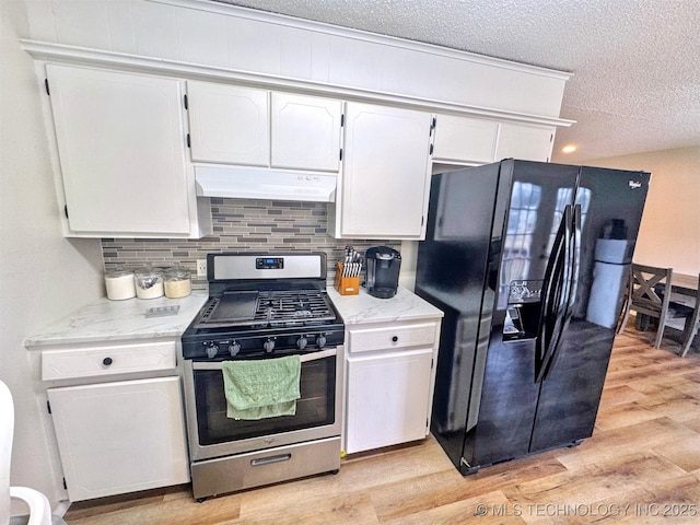 kitchen featuring white cabinetry, decorative backsplash, light hardwood / wood-style floors, black fridge, and stainless steel range with gas stovetop