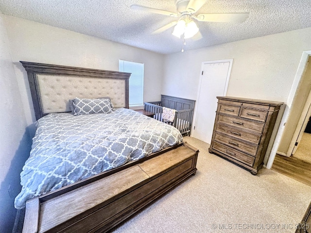 bedroom featuring ceiling fan, carpet, and a textured ceiling