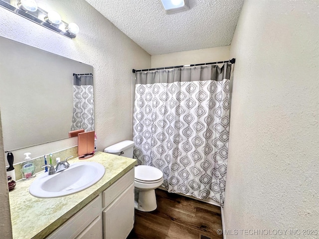 bathroom featuring hardwood / wood-style flooring, vanity, toilet, and a textured ceiling