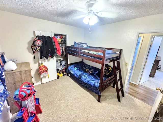 bedroom featuring ceiling fan, carpet floors, and a textured ceiling