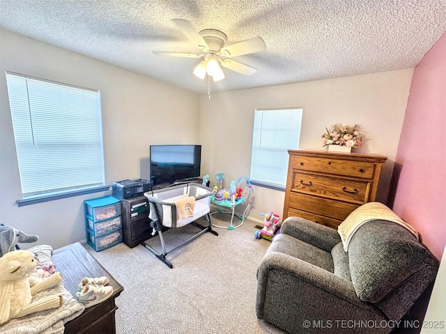 carpeted living room with ceiling fan and a textured ceiling