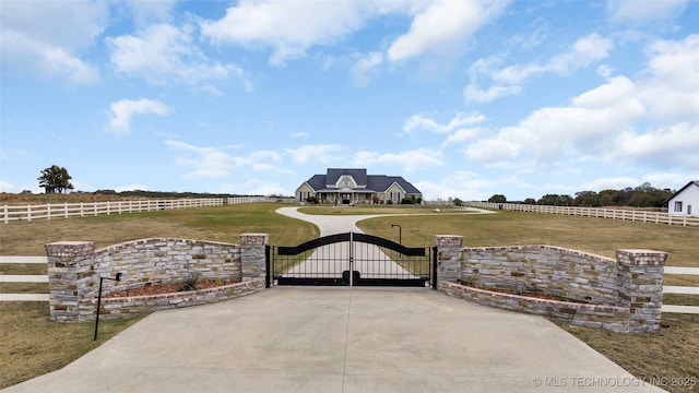 view of gate featuring a yard and a rural view