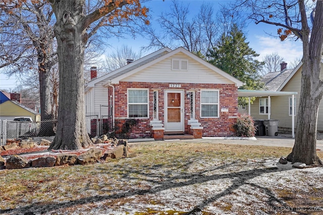 bungalow-style house featuring a carport, fence, brick siding, and a chimney