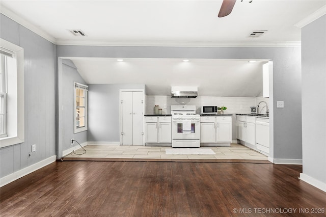 kitchen featuring white appliances, crown molding, tasteful backsplash, light hardwood / wood-style floors, and white cabinets