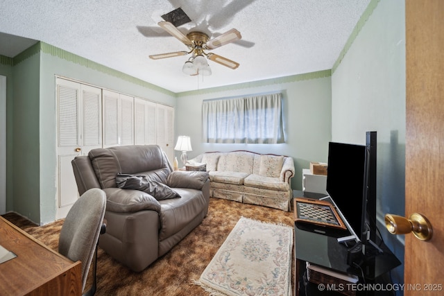 living room with a textured ceiling and ceiling fan