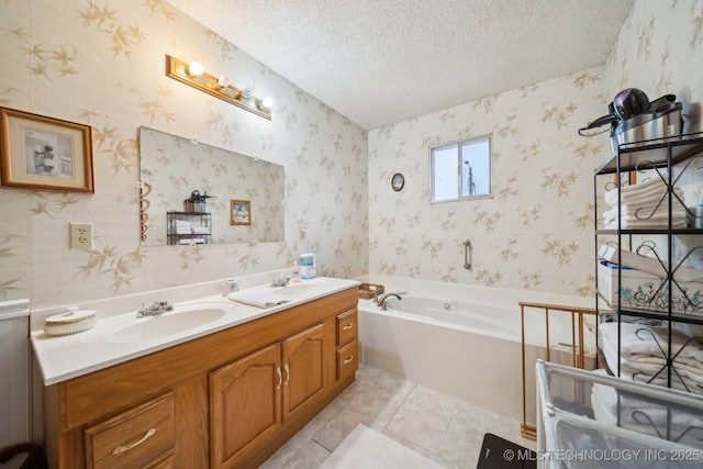 bathroom with tile patterned floors, a bathing tub, a textured ceiling, and vanity