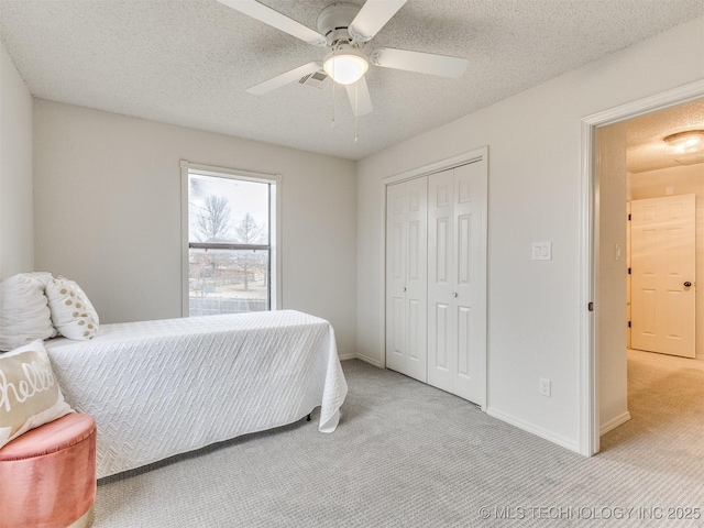 bedroom with light carpet, a closet, and a textured ceiling