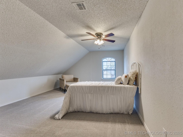 bedroom with light carpet, visible vents, a textured wall, lofted ceiling, and a textured ceiling