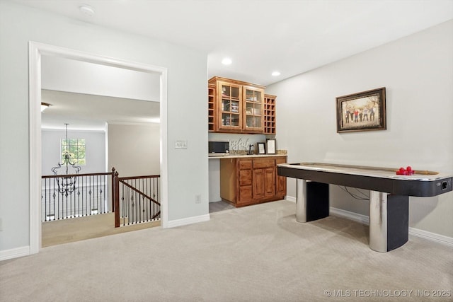 interior space with a notable chandelier, baseboards, and light colored carpet
