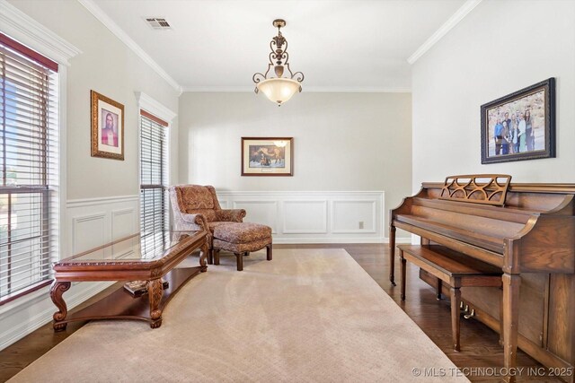 sitting room with visible vents, wainscoting, crown molding, and wood finished floors