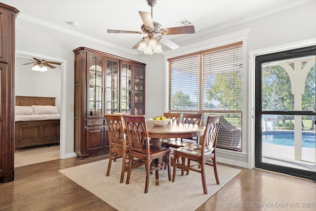 dining space with hardwood / wood-style flooring, ceiling fan, and ornamental molding