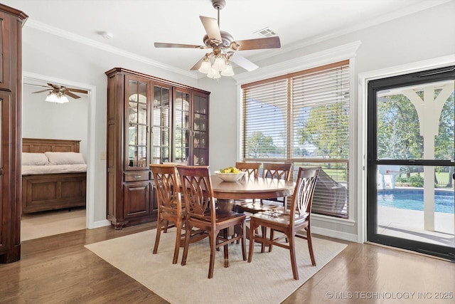 dining area with ornamental molding, wood finished floors, and ceiling fan