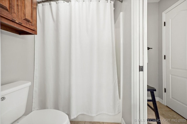bathroom with tile patterned flooring, curtained shower, and toilet