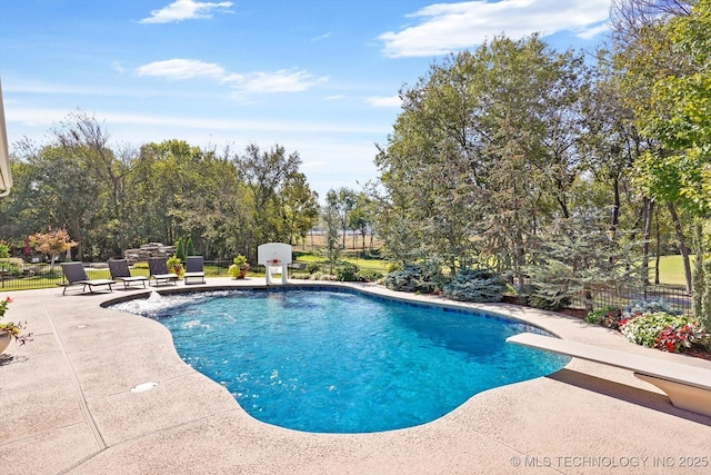 pool with a diving board, a patio, and fence