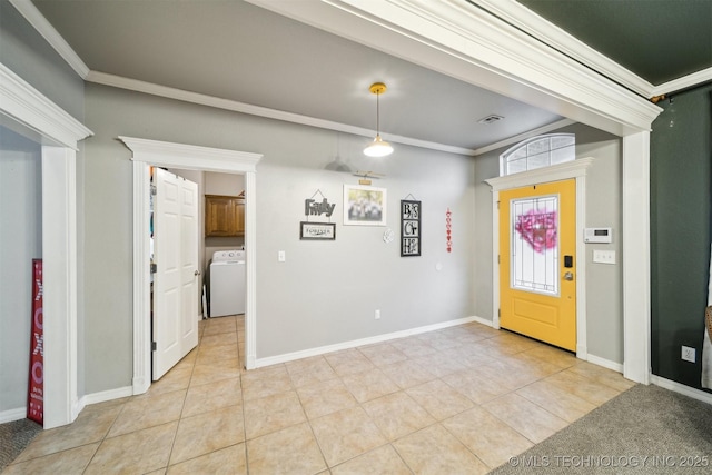 tiled foyer entrance with washer / dryer and ornamental molding