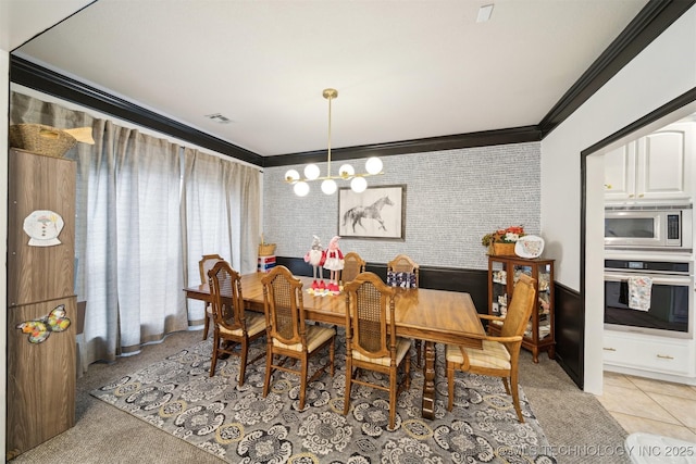 dining area featuring ornamental molding, a chandelier, and light tile patterned floors