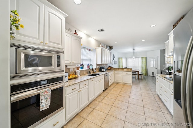 kitchen with sink, decorative light fixtures, white cabinets, and appliances with stainless steel finishes