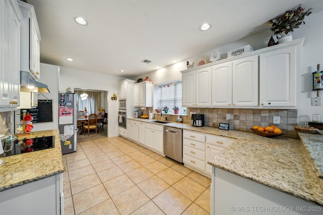 kitchen with tasteful backsplash, white cabinetry, appliances with stainless steel finishes, and light stone counters