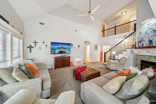 living room featuring ceiling fan, carpet, lofted ceiling, and a fireplace