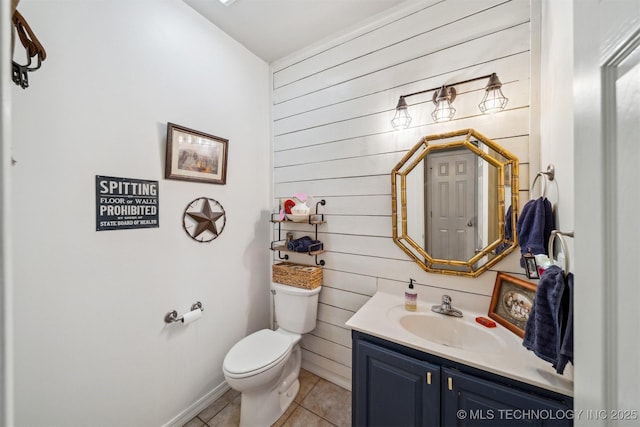 bathroom with tile patterned flooring, vanity, toilet, and wood walls