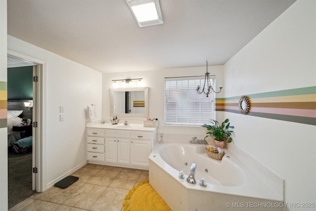 bathroom featuring tile patterned flooring, vanity, an inviting chandelier, and a bathtub