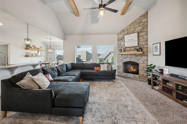 living room featuring beamed ceiling, a fireplace, plenty of natural light, and carpet flooring