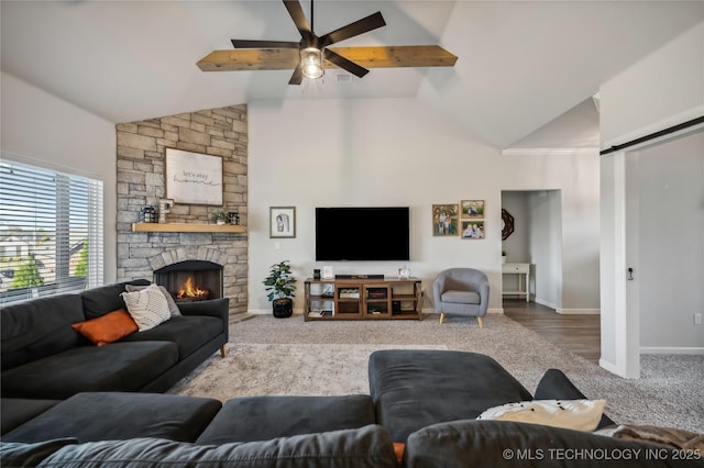 carpeted living room with a fireplace, high vaulted ceiling, a barn door, and ceiling fan