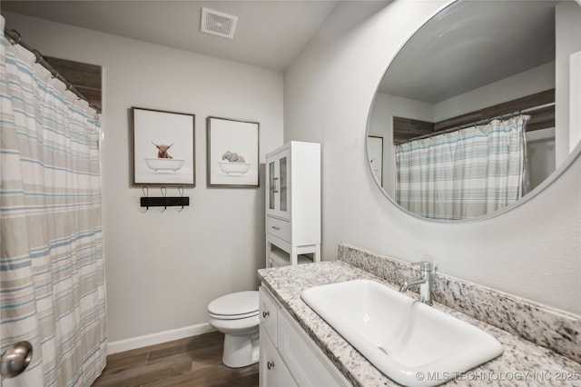 bathroom with wood-type flooring, vanity, and toilet