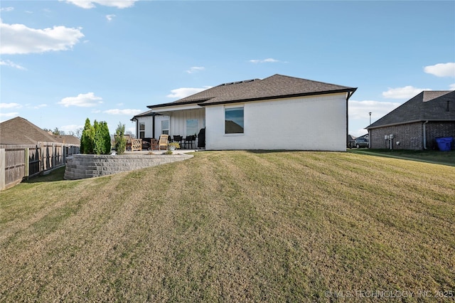 rear view of property featuring a yard