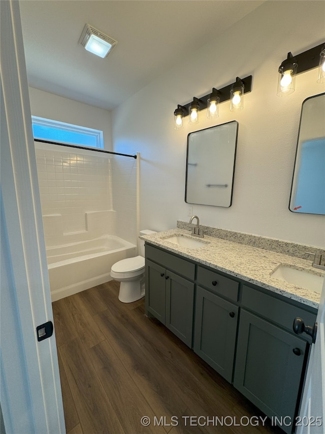 full bathroom featuring  shower combination, toilet, vanity, and wood-type flooring