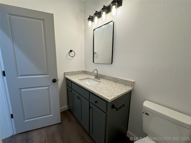 bathroom featuring toilet, hardwood / wood-style flooring, and vanity