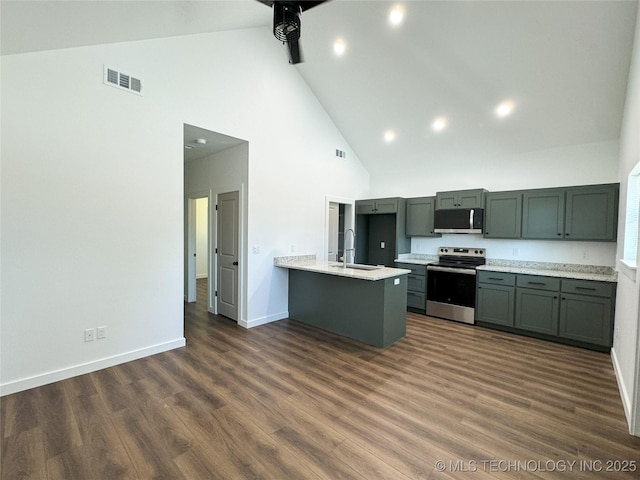 kitchen with appliances with stainless steel finishes, light stone counters, dark hardwood / wood-style flooring, sink, and kitchen peninsula