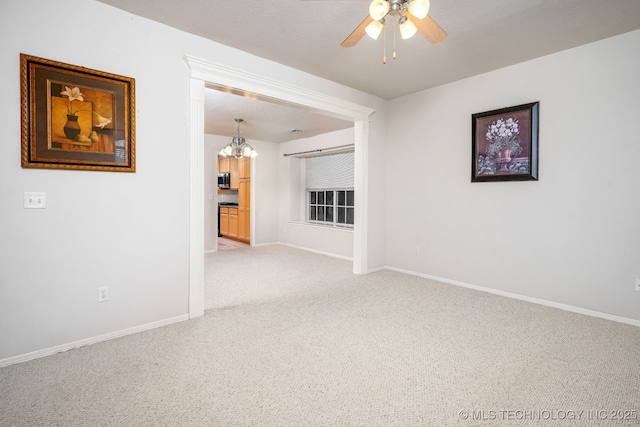 empty room with carpet flooring and ceiling fan with notable chandelier