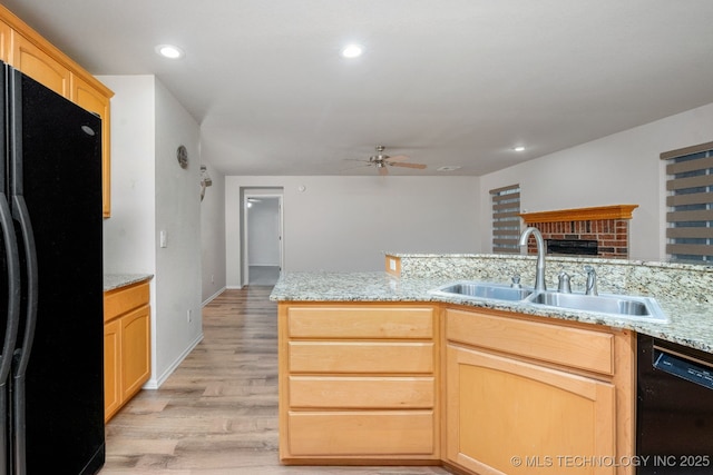 kitchen with light brown cabinetry, sink, ceiling fan, black appliances, and light wood-type flooring