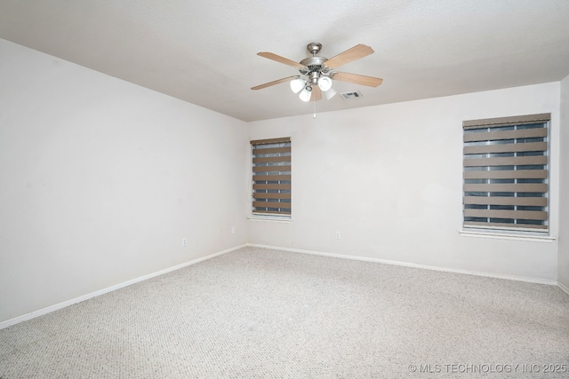 carpeted spare room with ceiling fan