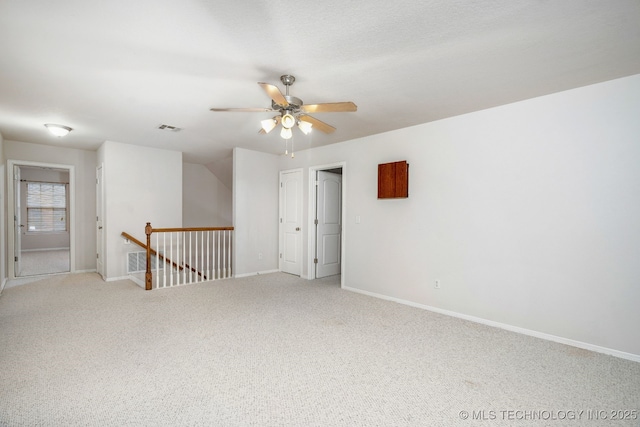 carpeted spare room featuring ceiling fan