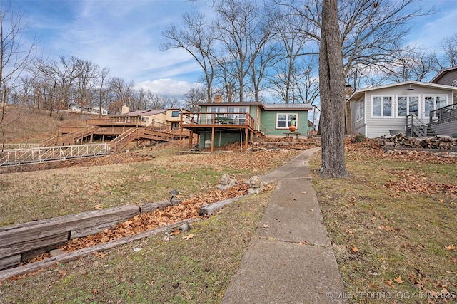 view of front of home with a front yard and a deck