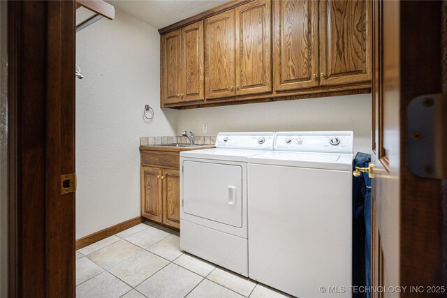 8775 Leonard St, Kingston, OK 73439 - laundry room with cabinets, washer and clothes dryer, sink, and light tile patterned floors
