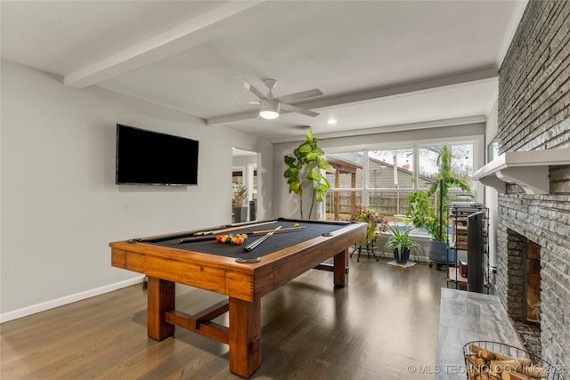 rec room featuring dark hardwood / wood-style floors, beamed ceiling, pool table, ceiling fan, and a brick fireplace