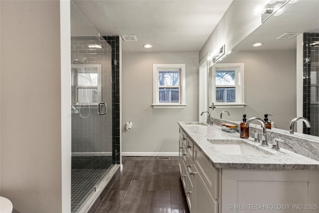 bathroom with walk in shower, vanity, and hardwood / wood-style floors