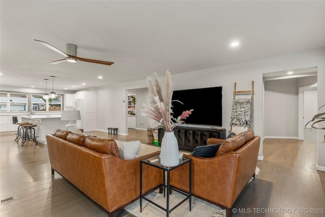 living room featuring ceiling fan and light hardwood / wood-style flooring